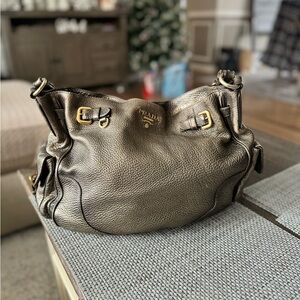 Used Prada pewter hand bag in great condition. Has both beauty and practicality.